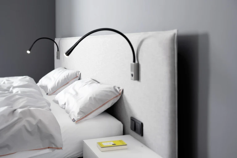 Flaches Boxspringbett mit gepolsterten Wandpaneel in flacher Kissenoptik