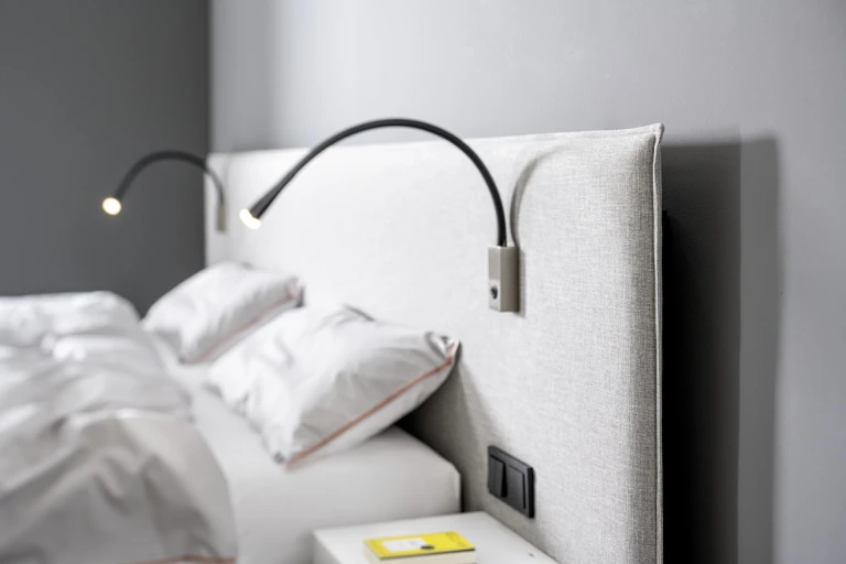 Flaches Boxspringbett mit gepolsterten Wandpaneel in flacher Kissenoptik