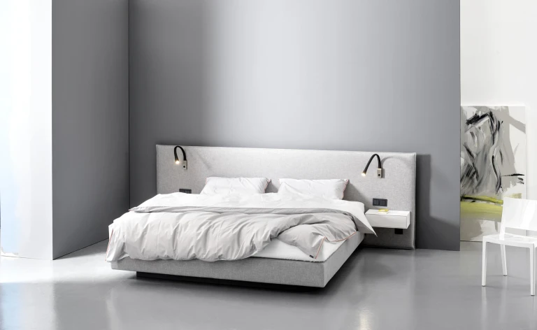 Flaches Boxspringbett mit gepolsterten Wandpaneel in flacher Kissenoptik
