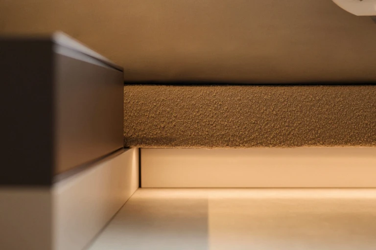 Ultraflaches Boxspringbett mit zweigeteiltem, gepolstertem Wandpaneel